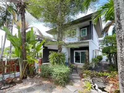 a house with palm trees in front of it at Cozy Serene Home Quiet Garden for a Peaceful Stay in Phuket Town