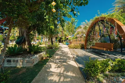 a park with a bench and a fence and trees at Rawayana West Villas & Kids Park in Rawai Beach