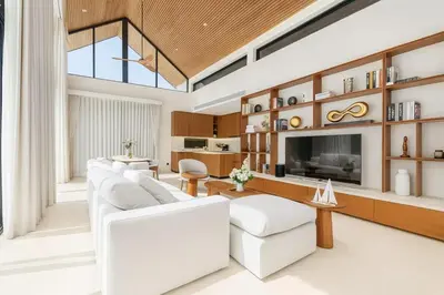a living room with white furniture and a flat screen tv at The White Courtyard Sanctuary 4BR Pool Viila in Koh Lone