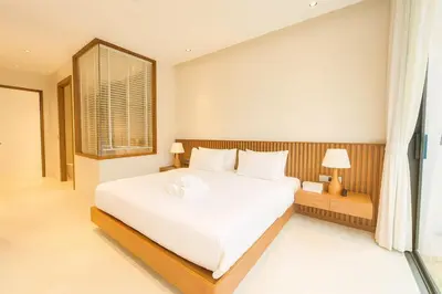 a bedroom with a large white bed and a window at The White Courtyard Sanctuary 4BR Pool Viila in Koh Lone
