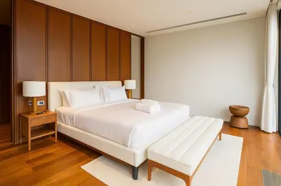 a bedroom with a large white bed and a bench at The White Courtyard Sanctuary 4BR Pool Viila in Koh Lone