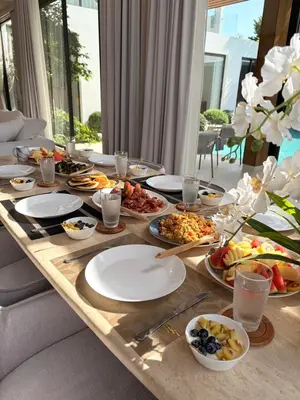 a long table with plates of food on it at The White Courtyard Sanctuary 4BR Pool Viila in Koh Lone