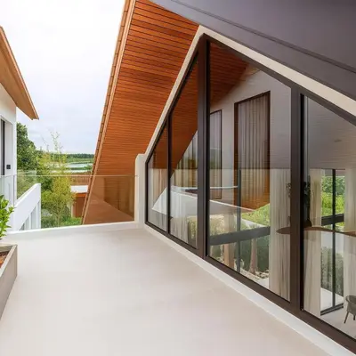 a house with glass doors and a balcony at The White Courtyard Sanctuary 4BR Pool Viila in Koh Lone