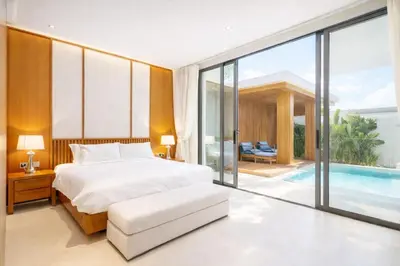 a bedroom with a bed and a swimming pool at The White Courtyard Sanctuary 4BR Pool Viila in Koh Lone