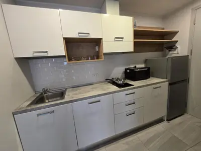 a kitchen with white cabinets and a sink and a refrigerator at Urban Chill -1 Bedroom (T2-216) in Phuket Town