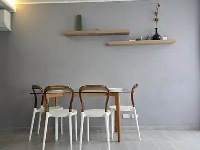 a table with four chairs and a white wall at Urban Chill -1 Bedroom (T2-216) in Phuket Town