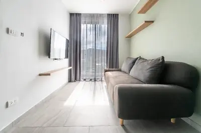 a living room with a couch and a large window at Charming 1-Bed Apt (T3- 629) in Phuket Town