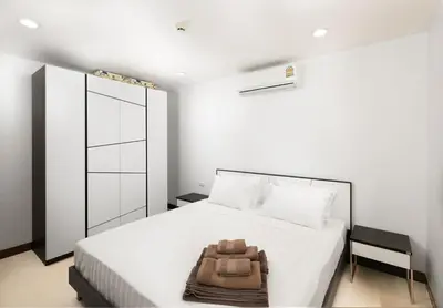 a bedroom with a bed with a bag on it at Karon Sea View 2 Bedrooms Apartment in Karon Beach