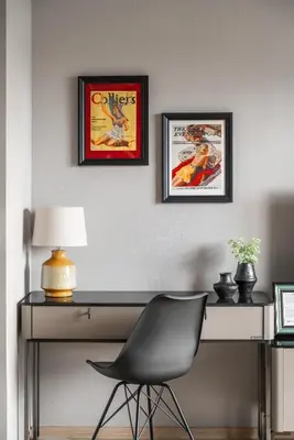 a desk with two framed posters on a wall with a chair at The Title Legendary Vintage Gloss in Bang Tao Beach