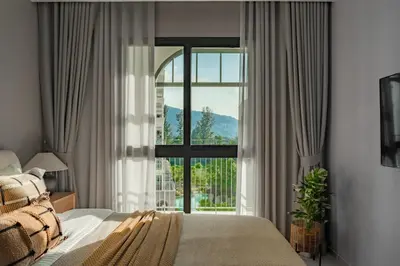 a bedroom with a bed and a large window at The Title Legendary Nature Flow in Bang Tao Beach