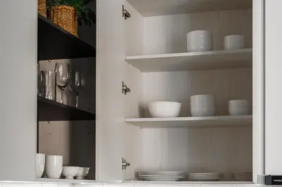 a kitchen cabinet with plates and bowls and glasses at The Title Legendary Nature Flow in Bang Tao Beach