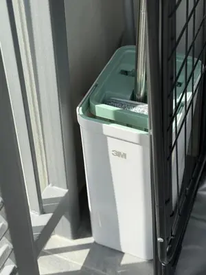 a white trash can with a green lid next to a door at The Title Legendary Nature Flow in Bang Tao Beach