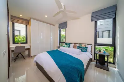 a bedroom with a bed and a desk and windows at Laguna park 5bedroom private pool villa in Laguna Phuket