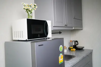 a microwave on top of a refrigerator in a kitchen at Title - Comfortable 1BR Tropical Retreat in Nai Yang Beach