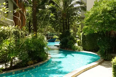 a pool in the middle of a resort with trees at Title - Comfortable 1BR Tropical Retreat in Nai Yang Beach