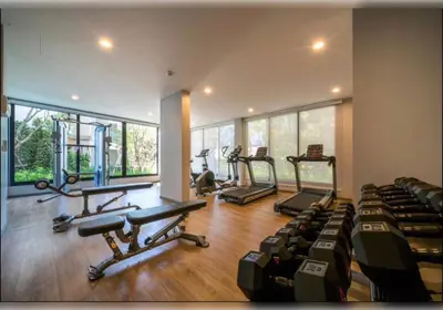 a gym with several treadmills and elliptical machines at Title - Comfortable 1BR Tropical Retreat in Nai Yang Beach