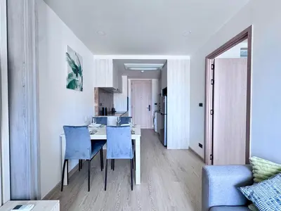 a kitchen and dining room with a table and blue chairs at Ozone Condominium in Laguna Phuket