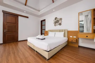 a bedroom with a white bed and a wooden floor at Villa Hemi 2BR Modern Thai Style with Private Pool in Rawai Beach