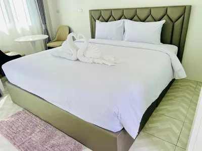 a bedroom with two swans towels on a bed at Sarona House 3 in Ban Thalat Choeng Thale