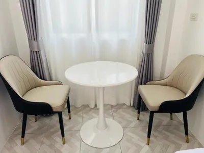 two chairs and a white table in a room at Sarona House 3 in Ban Thalat Choeng Thale