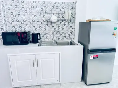 a kitchen with a sink and a refrigerator at Sarona House 3 in Ban Thalat Choeng Thale