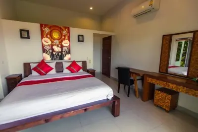 a bedroom with a bed and a desk and a mirror at Sunset bay view villa krabi in Ban Khao Thong
