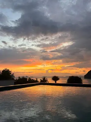 a sunset over a swimming pool with the sky at Sunset bay view villa krabi in Ban Khao Thong