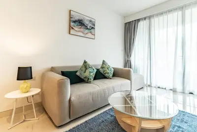 a living room with a couch and a glass table at Cassia Residence by Villacarte in Laguna Phuket