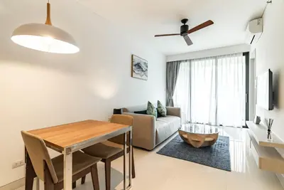 a living room with a table and a couch at Cassia Residence by Villacarte in Laguna Phuket