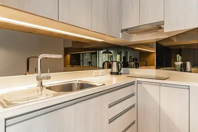 a kitchen with white cabinets and a sink at Cassia Residence by Villacarte in Laguna Phuket