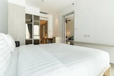 a white bedroom with a large white bed at Cassia Residence by Villacarte in Laguna Phuket