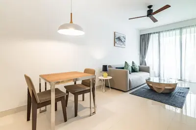 a living room with a table and chairs and a couch at Cassia Residence by Villacarte in Laguna Phuket