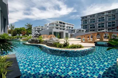a swimming pool with a bridge in front of a building at Duplex 1 BR Apt UTL B112 - Direct Pool Access in Rawai Beach