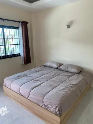 a large bed in a bedroom with a window at ZAMZAM House in Thalang