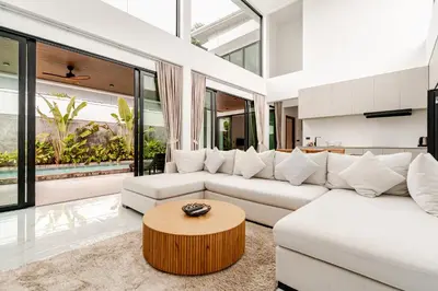 a living room with a white couch and a table at 3BR Pool Villa JAAI in Ban Saiyuan (1)