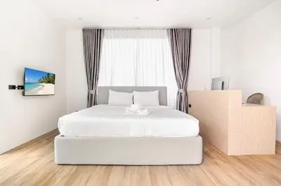 a white bedroom with a white bed and a window at 3BR Pool Villa JAAI in Ban Saiyuan (1)
