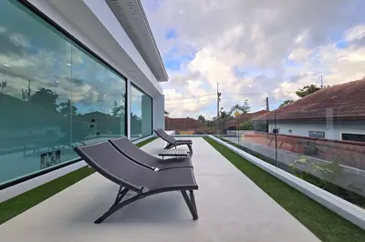 two benches sitting on the balcony of a house at 3BR Pool Villa JAAI in Ban Saiyuan (1)