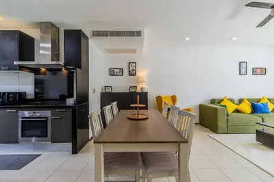a kitchen and living room with a table and a couch at C254 Condo 2BR Pool View Short Walk to Beach in Thalang