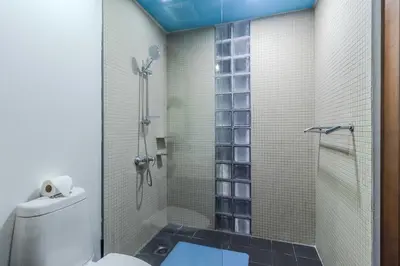 a bathroom with a shower with a toilet and a glass door at C254 Condo 2BR Pool View Short Walk to Beach in Thalang