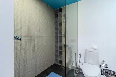 a bathroom with a toilet and a glass shower at C254 Condo 2BR Pool View Short Walk to Beach in Thalang