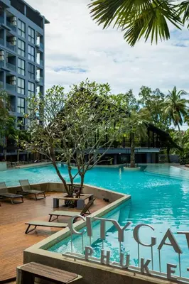 a swimming pool with a tree in front of a building at C252 Great Facility Condo Near Beach & Rooftop Pool in Kamala Beach