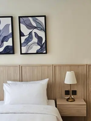 a bedroom with a bed and two pictures on the wall at Wora Phuket in Ban Sam Kong