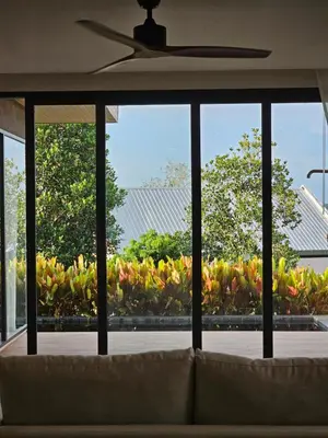a couch in a living room looking out a window at Wora Phuket in Ban Sam Kong