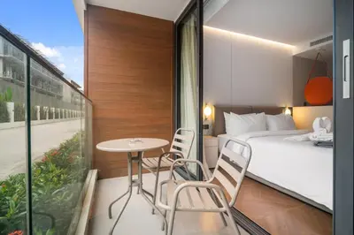a hotel room with a bed and a table and chairs at Kora Resort A110 – Luxury Beachfront Studio in Phuket Town