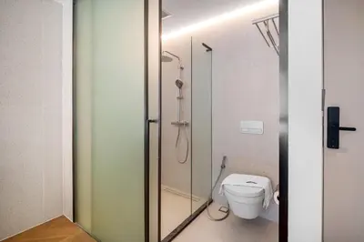 a bathroom with a glass shower with a toilet at Kora Resort A110 – Luxury Beachfront Studio in Phuket Town