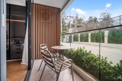 a patio with two chairs and a table on a balcony at Kora Resort A110 – Luxury Beachfront Studio in Phuket Town