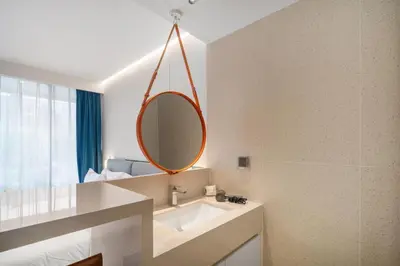 a bathroom with a sink and a mirror at Kora Resort A110 – Luxury Beachfront Studio in Phuket Town