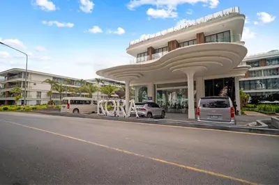 a white building with cars parked in front of it at Kora Resort A110 – Luxury Beachfront Studio in Phuket Town