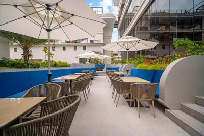 an outdoor seating area with tables and umbrellas at Kora Resort A110 – Luxury Beachfront Studio in Phuket Town
