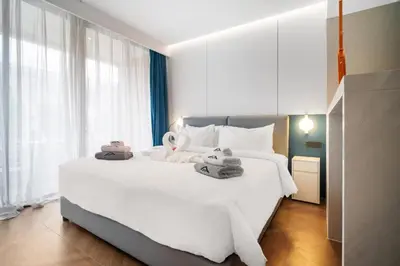 a bedroom with a large white bed with towels on it at Kora Resort A110 – Luxury Beachfront Studio in Phuket Town